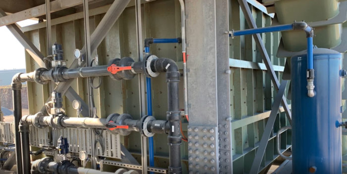 Load Out Bin. Water spray valves and piping in the foreground.